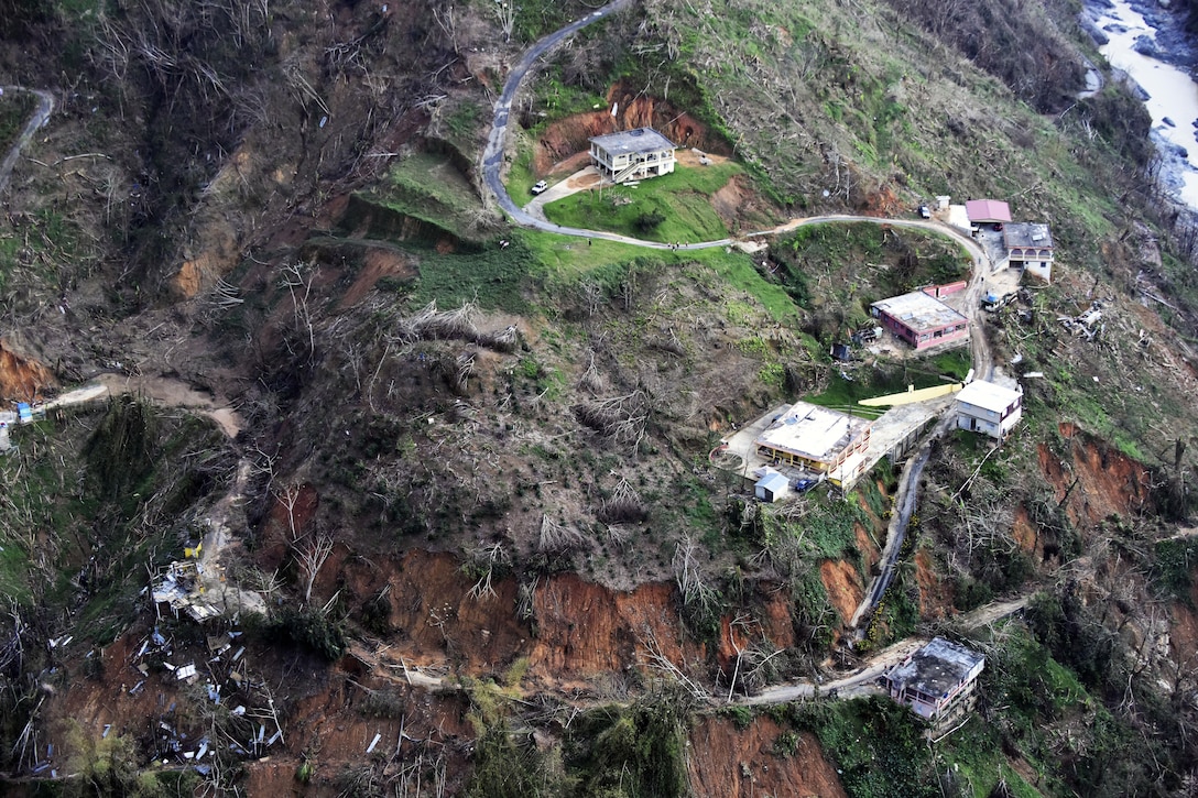 As viewed from above, a washed out road and buildings.