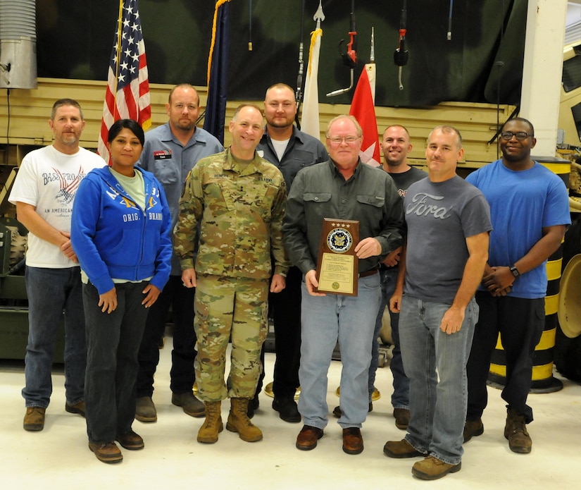 Major Gen. Patrick Reinert, commanding general of the 88th Regional Support Command, poses with Paul Harvey, center, the heavy mobile equipment repairer supervisor for Area Maintenance Support Activity 131, and the rest of the AMSA 131 shop with the plaque for winning the Level I, Company TDA category of the Fiscal Year 2016 Supply Excellence Awards (SEA) for the U.S. Army Reserve.