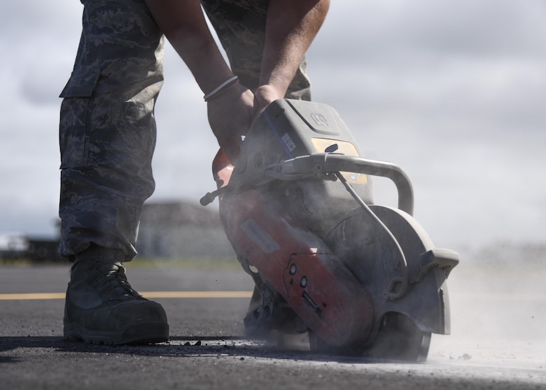 U.S. Air Force Staff Sgt. Trevor Harrison, 633rd Civil Engineer Squadron pavements and construction craftsman, cuts pavement with a power saw at Joint Base Langley-Eustis, Va., Sept. 25, 2017.