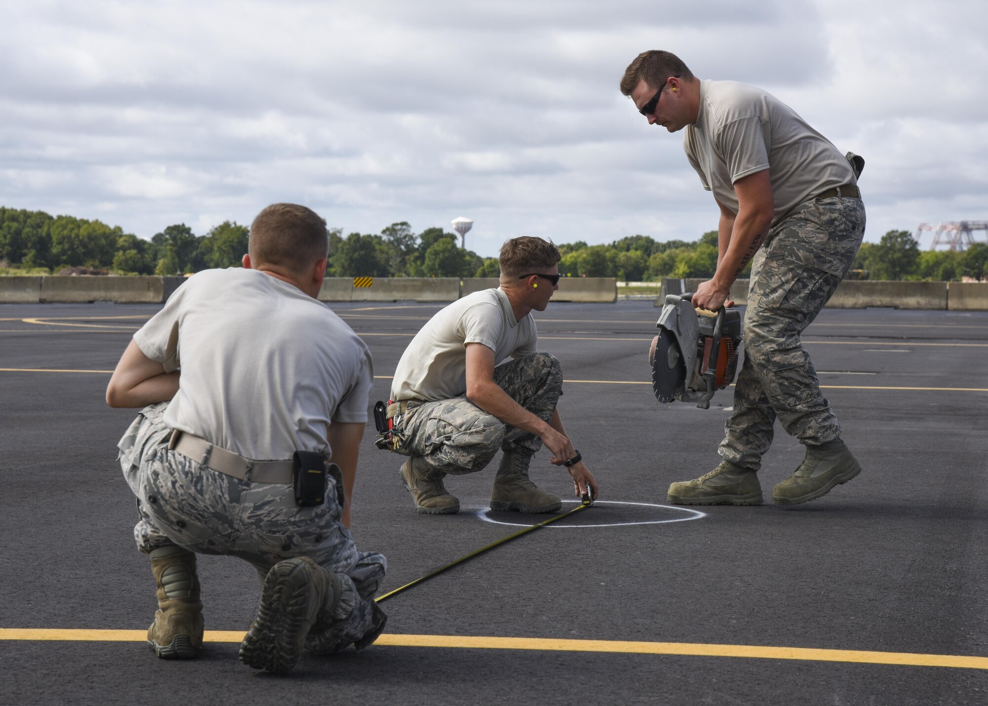 (From Left) U.S. Air Force Airman 1st Class Brandon Whittle, 633rd Civil Engineer Squadron pavements and construction apprentice, Senior Airman Corey Reeves, 633rd CES pavements and construction craftsman, and Staff Sgt. Trevor Harrison, 633rd CES pavements and construction craftsman, prepare to cut the pavement at Joint Base Langley-Eustis, Va., Sept. 25, 2017.