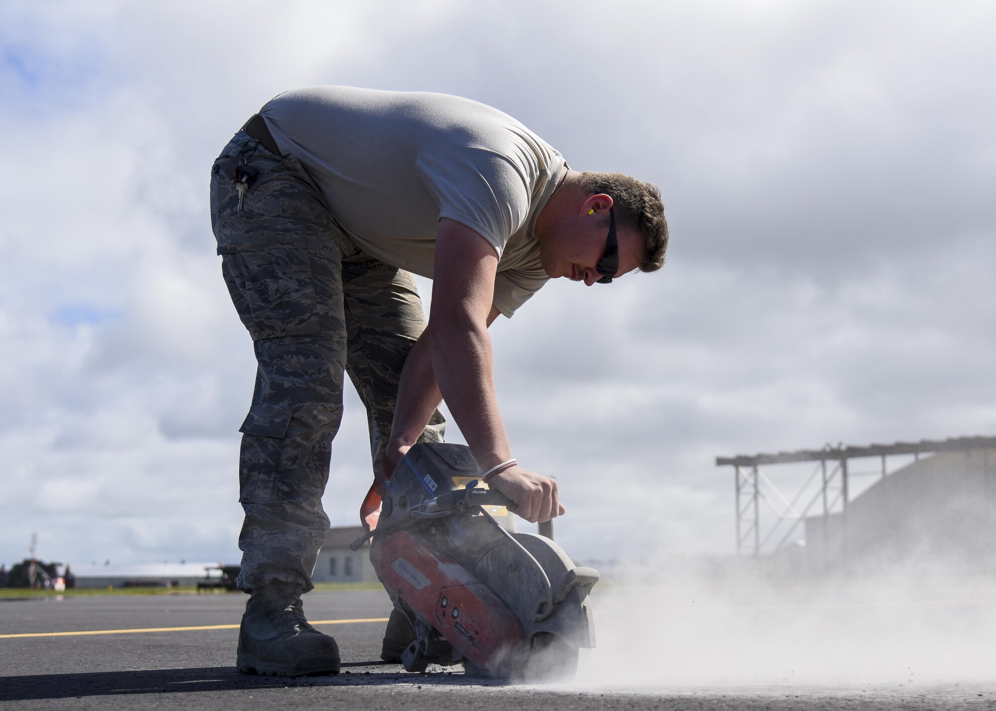 U.S. Air Force Staff Sgt. Trevor Harrison, 633rd Civil Engineer Squadron pavements and construction craftsman cuts the pavement with a power saw at Joint Base Langley-Eustis, Va., Sept. 25, 2017.