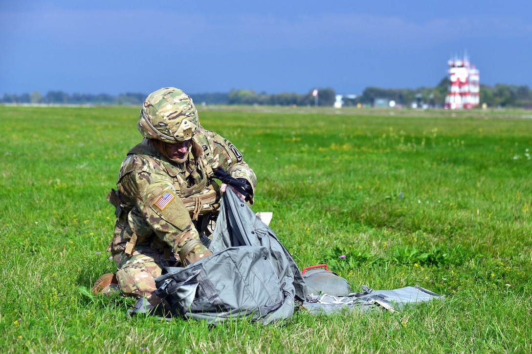 A U.S. soldier recovers a parachute during an airborne operation at Rivolto Air Base in Udine, Italy.