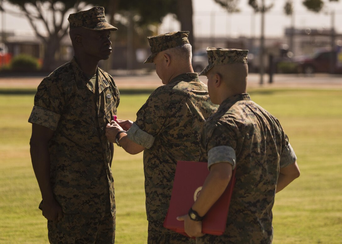 U.S. Marine Corps Sgt. Maj. Delvin R. Smythe, the Marine Corps Air Station (MCAS) Yuma, Ariz., sergeant major, receives awards from Col. Ricardo Martinez, the outgoing commanding officer of MCAS Yuma, and Master Gunnery Sgt. Arthur Parra, the acting sergeant major of MCAS Yuma, during Sgt. Maj. Smythe's retirement ceremony, June 30, 2017. (U.S. Marine Corps photo taken by Lance Cpl. Christian Cachola)