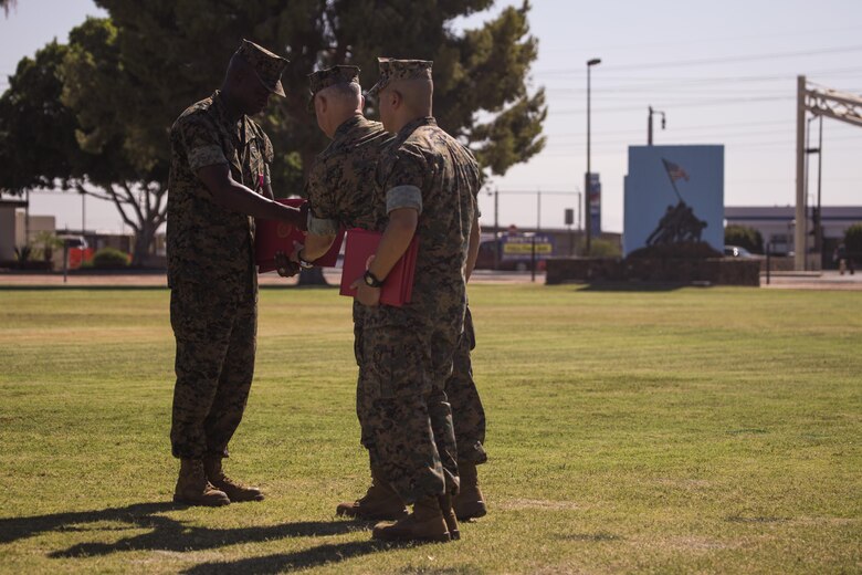 U.S. Marine Corps Sgt. Maj. Delvin R. Smythe, the Marine Corps Air Station (MCAS) Yuma, Ariz., sergeant major, receives awards from Col. Ricardo Martinez, the outgoing commanding officer of MCAS Yuma, and Master Gunnery Sgt. Arthur Parra, the acting sergeant major of MCAS Yuma, during Sgt. Maj. Smythe's retirement ceremony, June 30, 2017. (U.S. Marine Corps photo taken by Lance Cpl. Christian Cachola)