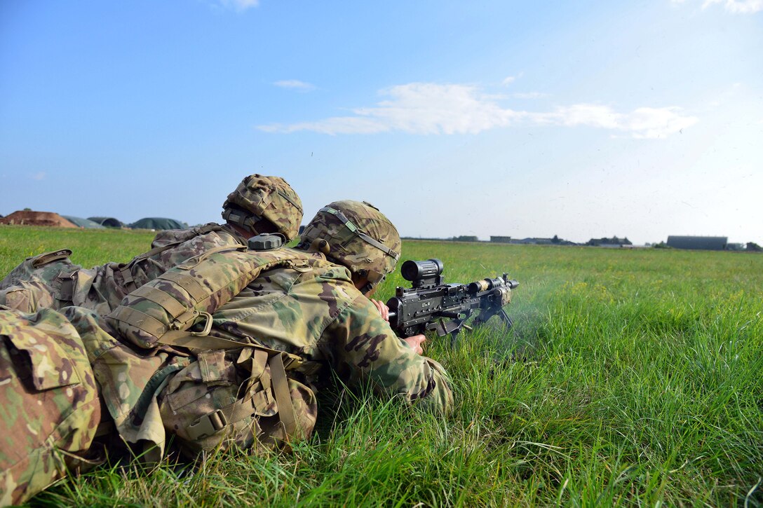 U.S. soldiers fire a machine gun at Rivolto Air Base in Udine, Italy.