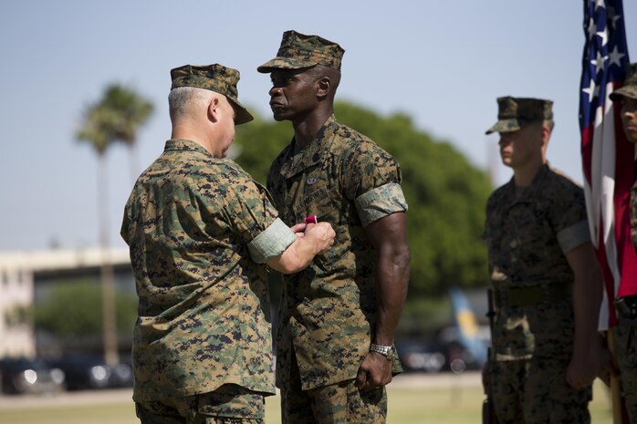 U.S. Marine Corps Sgt. Maj. Delvin R. Smythe, the Marine Corps Air Station (MCAS) Yuma, Ariz., sergeant major, receives awards from Col. Ricardo Martinez, the outgoing commanding officer of MCAS Yuma, and Master Gunnery Sgt. Arthur Parra, the acting sergeant major of MCAS Yuma, during Sgt. Maj. Smythe's retirement ceremony, June 30, 2017. (U.S. Marine Corps photo taken by Lance Cpl. Joel Soriano)