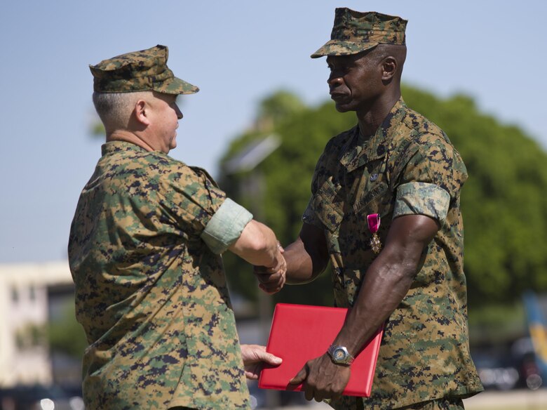 U.S. Marine Corps Sgt. Maj. Delvin R. Smythe, the Marine Corps Air Station (MCAS) Yuma, Ariz., sergeant major, receives awards from Col. Ricardo Martinez, the outgoing commanding officer of MCAS Yuma, and Master Gunnery Sgt. Arthur Parra, the acting sergeant major of MCAS Yuma, during Sgt. Maj. Smythe's retirement ceremony, June 30, 2017. (U.S. Marine Corps photo taken by Lance Cpl. Joel Soriano)