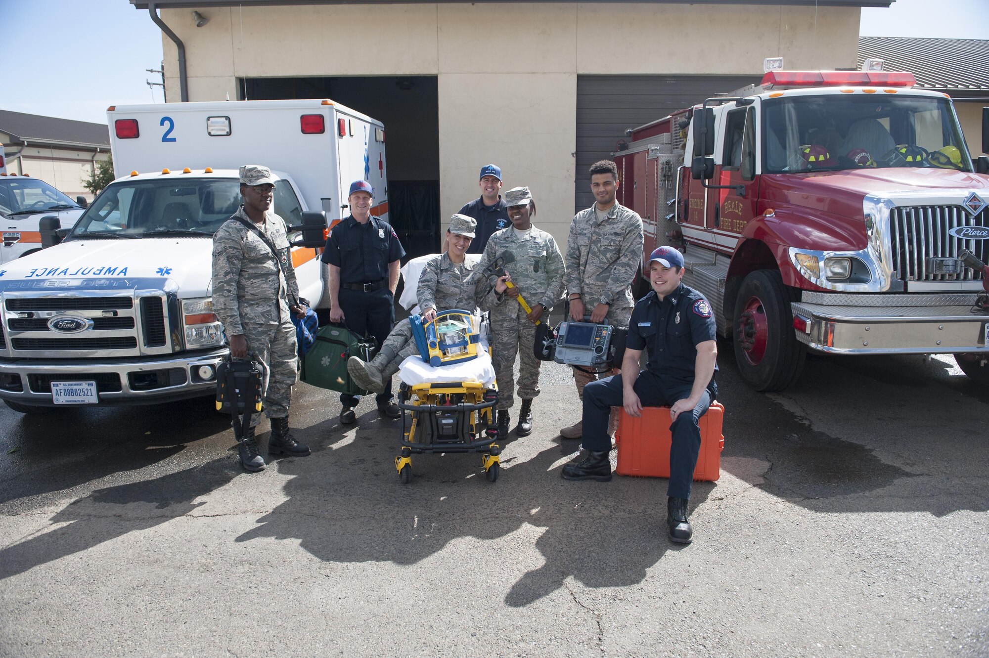 Airmen with the 9th Medical Group and 9th Civil Engineer Squadron, pose for  a photo at Station 2 at Beale Air Force Base, California, Oct. 3, 2017. Medics relocated to the fire station in an attempt to reduce radio issues caused by lack of reception on base. (U.S. Air Force photo/Senior Airman Justin Parsons)