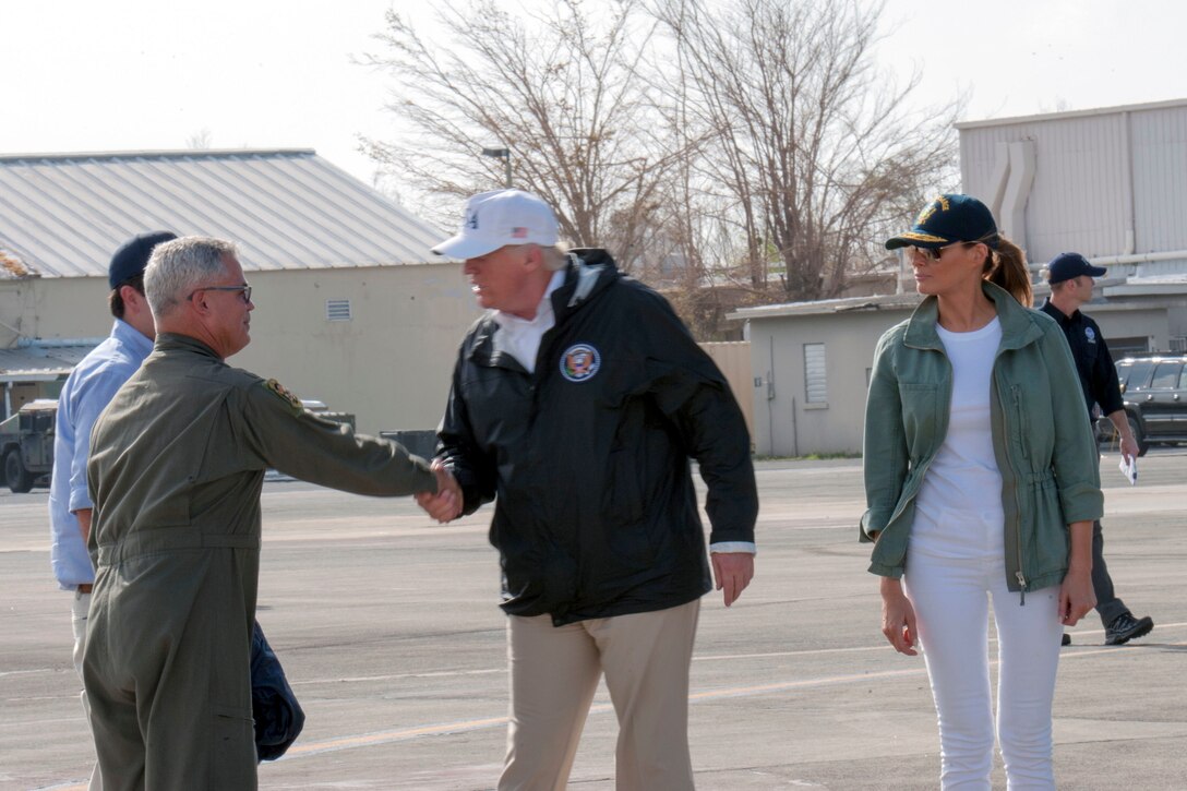 The president shakes hands with an airman.