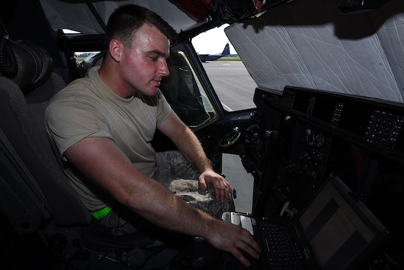 Male sits in flight deck monitoring plane systems