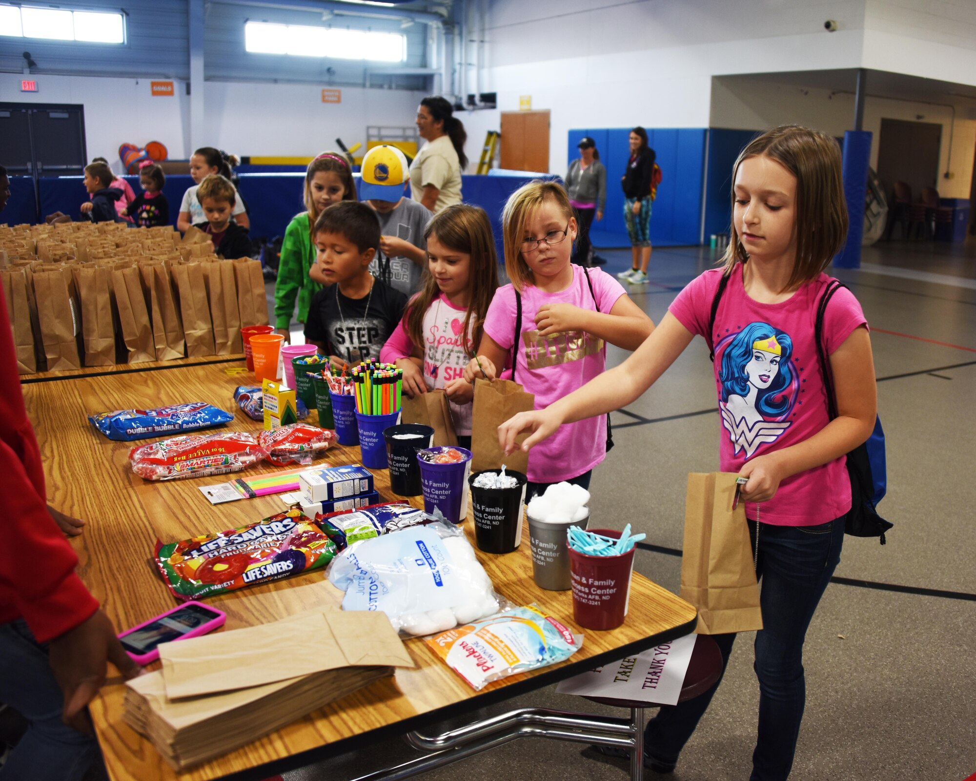 Children from across the base gather goodies for their deployment bag during a kid’s deployment day event Sept. 29, 2017, at Grand Forks Air Force Base, North Dakota. The deployment day was sponsored by the Network 5/6 whose goal was to give the kids a feel for what a deployment is like. (U.S. Air Force photo/Senior Airman Cierra Presentado)