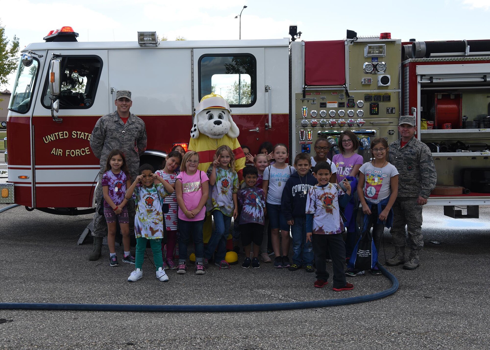 Children pose with members of the Fire Department and Sparky the dog during a kid’s deployment day event Sept. 29, 2017, at Grand Forks Air Force Base, North Dakota. The event was held to give children of military members the chance to experience what a deployment is like. (U.S. Air Force photo/Senior Airman Cierra Presentado)