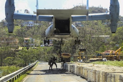 Marines attach a barrier to a V-22 Osprey tilt-rotor aircraft while working to reinforce the Guajataca Dam in Puerto Rico.