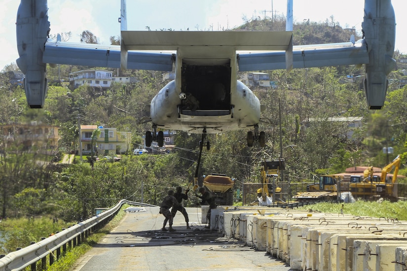 Marines attach a barrier to a V-22 Osprey tilt-rotor aircraft while working to reinforce the Guajataca Dam in Puerto Rico.