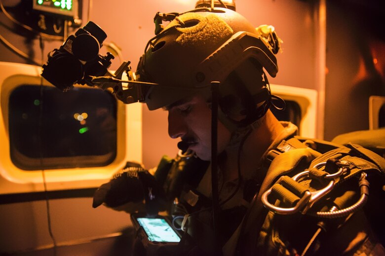 A Marine with the Force Reconnaissance Company, III Marine Expeditionary Force stationed at Camp Schwab in Okinawa, Japan examines his Android Tactical Assault Kit (ATAK) device on the aircraft before the team jumps at IDIS-Corps facility in Parker, Ariz., from July 12 to August 1, 2017. The Marines conducted high altitude high opening (HAHO) sustainment training, while implementing the Joint Precision Air Drop System (JPADS).  The Marine shown in the photo is the team leader and is tracking his team and the drop zone position.