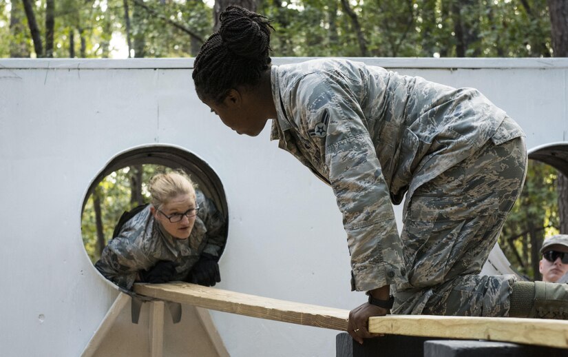 Airman 1st Class Genise Brewton, 628th Civil Engineer Squadron water and fuels system maintainer, assists Senior Airman Anastasia Stevens, 628th Civil Engineer Squadron entomologist, across a plank during basic combat readiness skills training course at McCrady Army National Guard Training Center, S.C., Sept. 26, 2017.