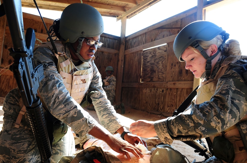 Airman 1st Class Genise Brewton, 628th Civil Engineer Squadron water and fuels system maintainer, and 2nd Lt. Darby Germain, 628th Force Support Squadron fitness and sports officer in charge, practice treating a simulated casualty on the field during the final day of Warfighter Skills Training at McCrady Army National Guard Training Center, S.C., Sept. 29, 2017