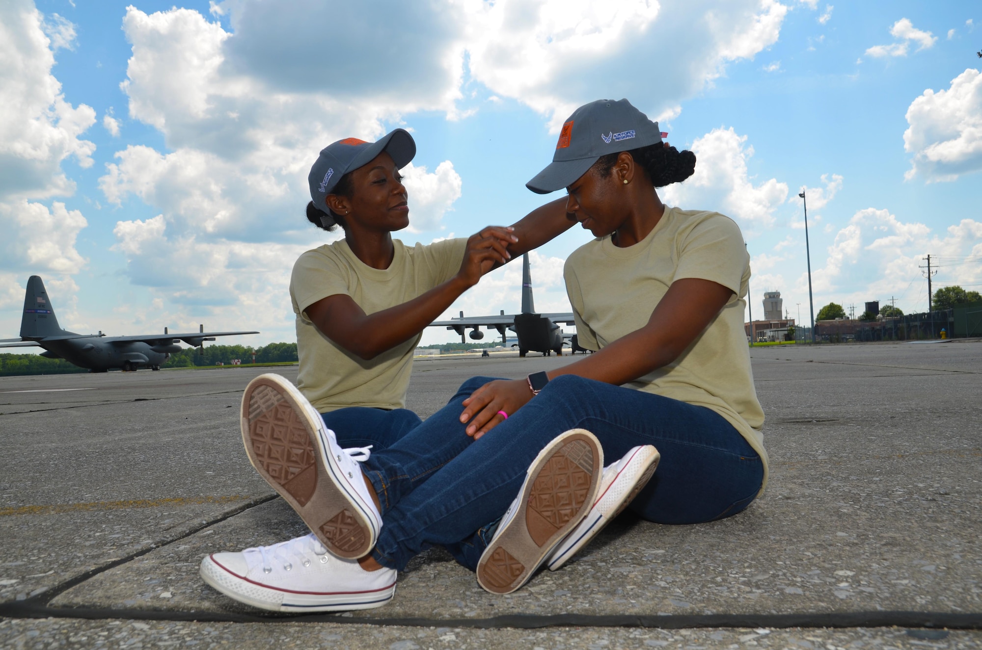 Shaina Williams adjusts Shannon Barber's hat as they pose for a photo on the flightline at Dobbins Air Reserve Base, Ga. July 9, 2017. The sisters are identical twins and currently train with the 94th Airlift Wing development and training flight. (U.S. Air Force photo/Senior Airman Lauren Douglas)