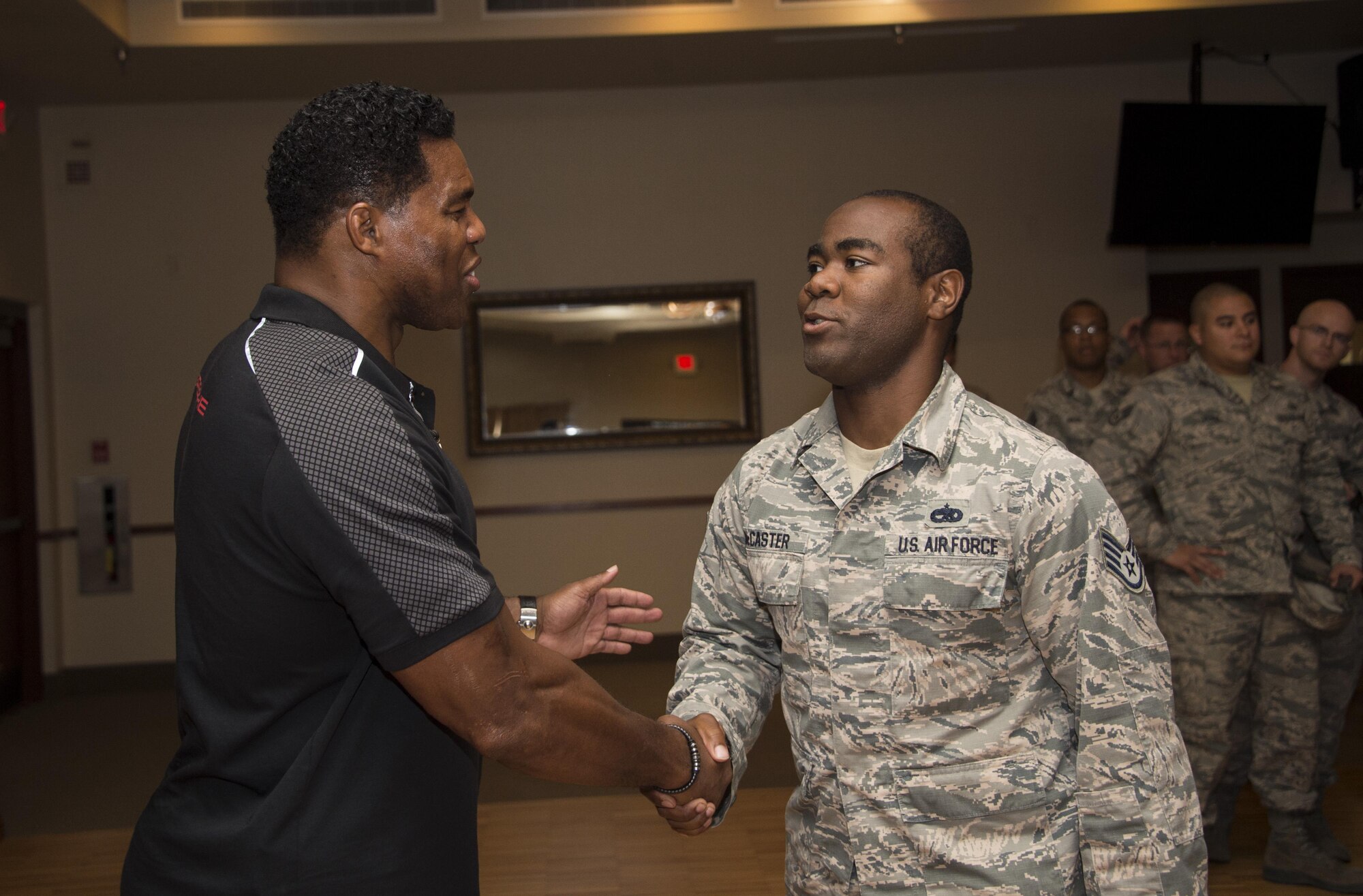 Herschel Walker, former professional athlete, shakes hands with Staff Sgt. Ned McCaster, 62nd Aircraft Maintenance Unit F-35 integrated avionics specialist, at Luke Air Force Base, Ariz., Oct. 3, 2017. Concluding his speech, Walker conducted a meet-and-greet and photo opportunity for all Airmen in attendance. (U.S. Air Force photo/Airman 1st Class Alexander Cook)