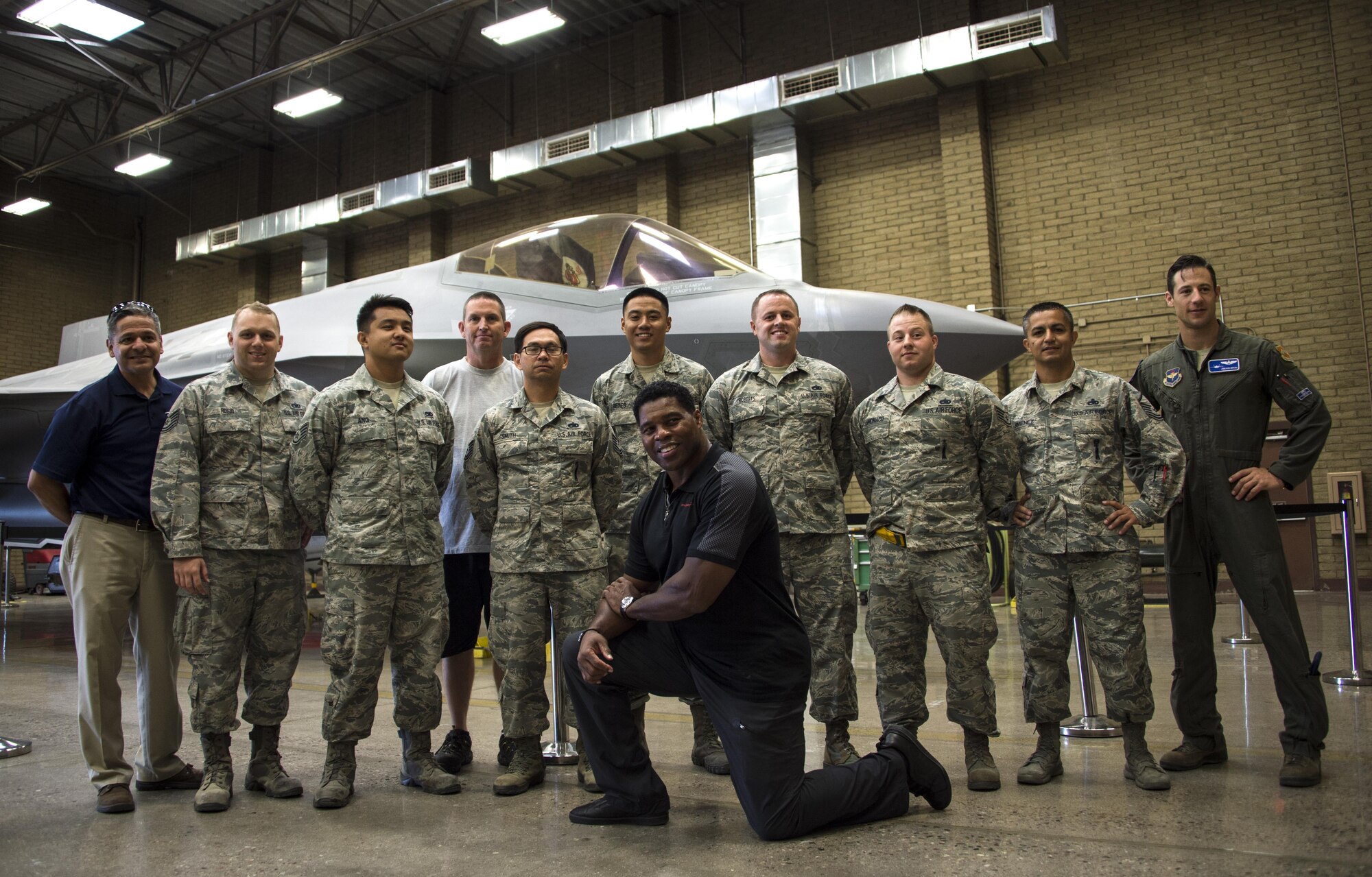 Herschel Walker, former professional athlete, takes a group photo with Airmen assigned to the 62nd Aircraft Maintenance Unit at Luke Air Force Base, Ariz., Oct. 3, 2017. During his visit, Walker went to various units around base to interact and spend one-on-one time with Airmen. (U.S. Air Force photo/Airman 1st Class Alexander Cook)