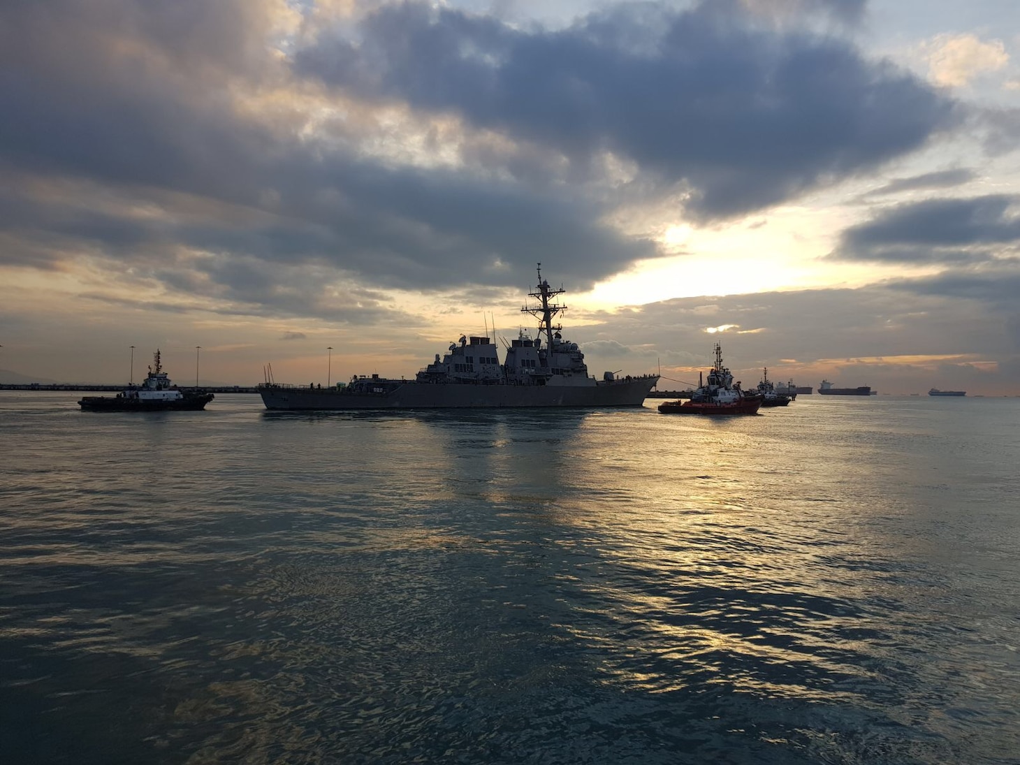 CHANGI, Singapore (NNS) - The Arleigh Burke-class guided missile destroyer USS John S. McCain (DDG 56) is towed away from the pier at Changi Naval Base, Oct. 5, to meet heavy lift transport vessel MV Treasure. Treasure will transport McCain to Fleet Activities Yokosuka for repairs.