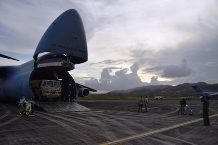 Storm clouds and a Caribbean sunset watch over Reserve Citizen Airmen as they unload a Joint Incident Site Communications Capability (JISCC) vehicle from an Air Force Reserve Command 433rd Airlift Wing C-5M Super Galaxy at Ceiba, Puerto Rico Oct. 1, 2017. The JISCC vehicle will provide satellite service while interlacing communication assets between the two agencies with internet, telephone, and radio communication. (U.S.  Air Force photo by Tech. Sgt. Carlos J. Treviño)