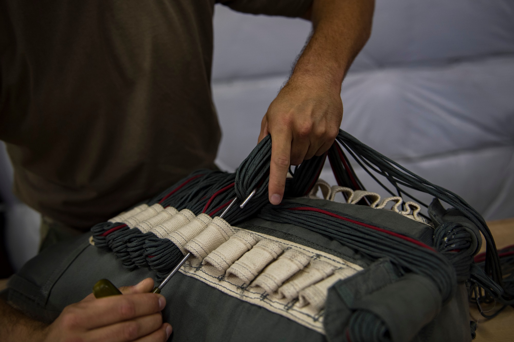 U.S. Air Force Staff Sgt. Sjon Green, 820th Combat Operations Squadron (COS) parachute rigger, secures an MC-6 parachutes lines, Oct. 4, 2017, at Moody Air Force Base, Ga. The 820th COS’s four-person shop of parachute rigger’s are responsible for ensuring every 820th Base Defense Group parachute is serviceable, while also ensuring ground safety at the drop zone. The team has packed and inspected more than 490 parachutes in 2017. (U.S. Air Force photo by Airman 1st Class Daniel Snider)