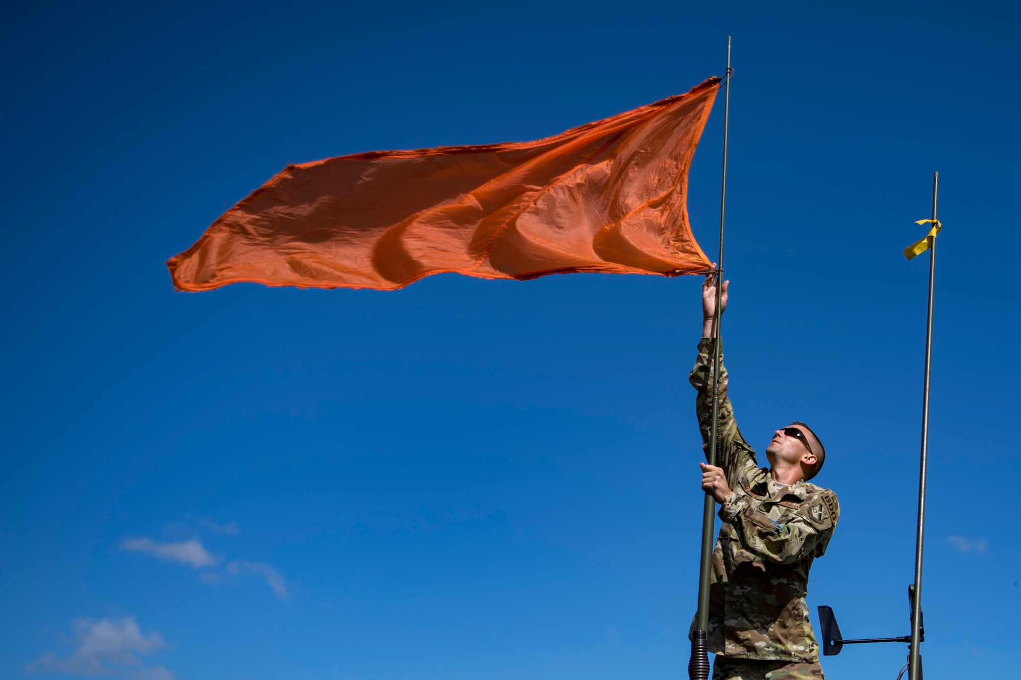 U.S. Air Force Tech. Sgt. John Schmidt, 820th Combat Operations Squadron (COS) NCO in charge of aircrew flight equipment, raises a flag that assists the drop-zone team in recognizing wind direction, Oct. 3, 2017, at the Lee Fulp drop zone in Tifton, Ga. The 820th COS’s four-person shop of parachute riggers are responsible for ensuring every 820th Base Defense Group parachute is serviceable, while also ensuring ground safety at the drop zone. The team has packed and inspected more than 490 parachutes in 2017. (U.S. Air Force photo by Airman 1st Class Daniel Snider)