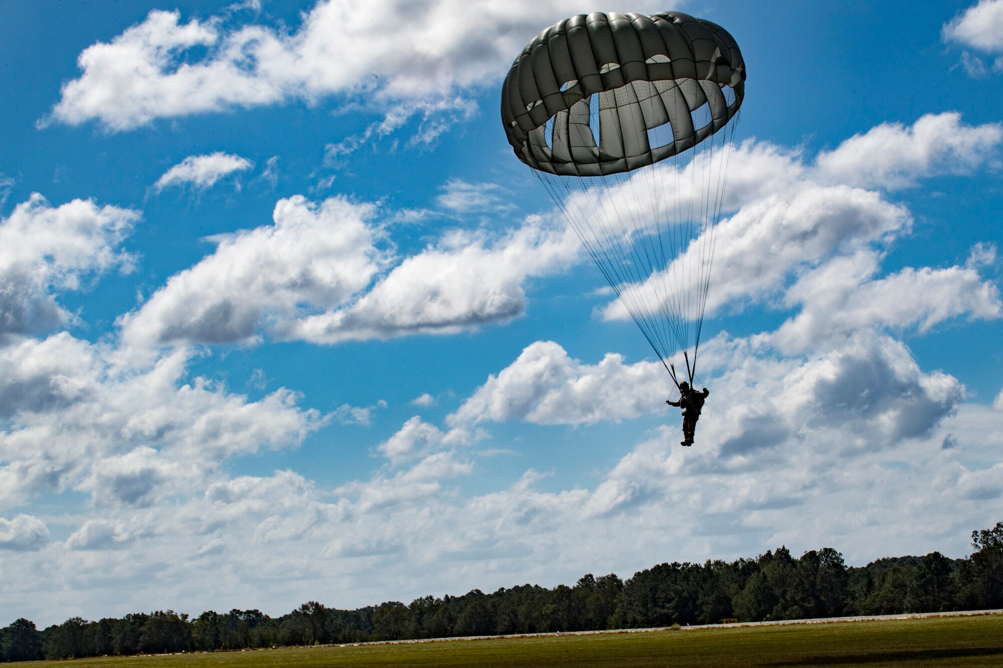 A member of the 820th Base Defense Group (BDG) descends during a static-line jump, Oct. 3, 2017, at the Lee Fulp drop zone in Tifton, Ga. The 820th Combat Operations Squadron’s four-person shop of parachute riggers are responsible for ensuring every 820th BDG parachute is serviceable, while also ensuring ground safety at the drop zone. The team has packed and inspected more than 490 parachutes in 2017. (U.S. Air Force photo by Airman 1st Class Daniel Snider)