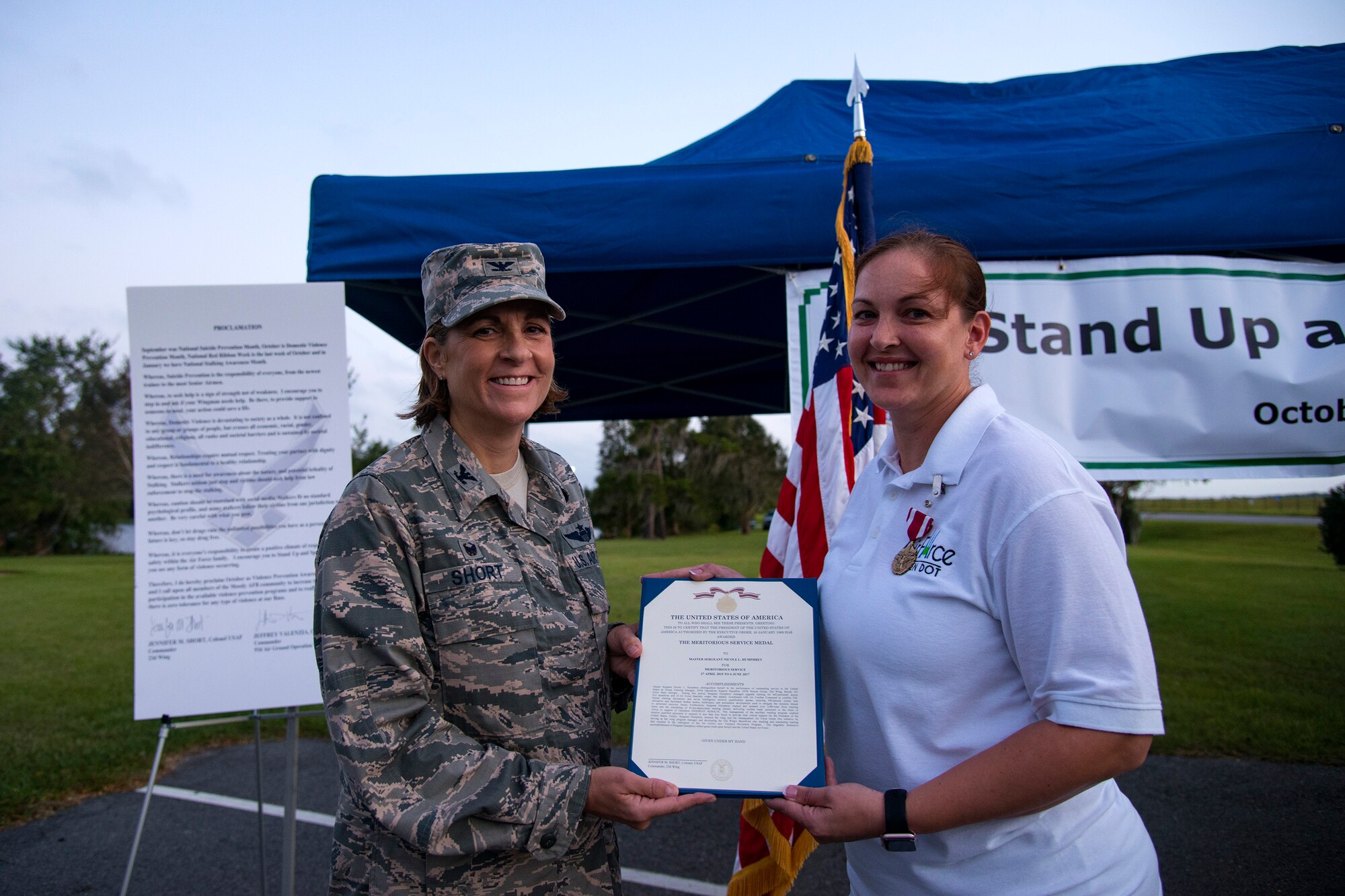 Col. Jennifer Short, 23d Wing commander, left, and Master Sgt. Nicole Humphrey, 23d Maintenance Group training section chief, pose for an award, Oct. 4, 2017, at Moody Air Force Base, Ga. Humphrey received the Meritorious Service Medal for her service with Green Dot, a training program dedicated to violence prevention. (U.S. Air Force photo by Airman 1st Class Erick Requadt)