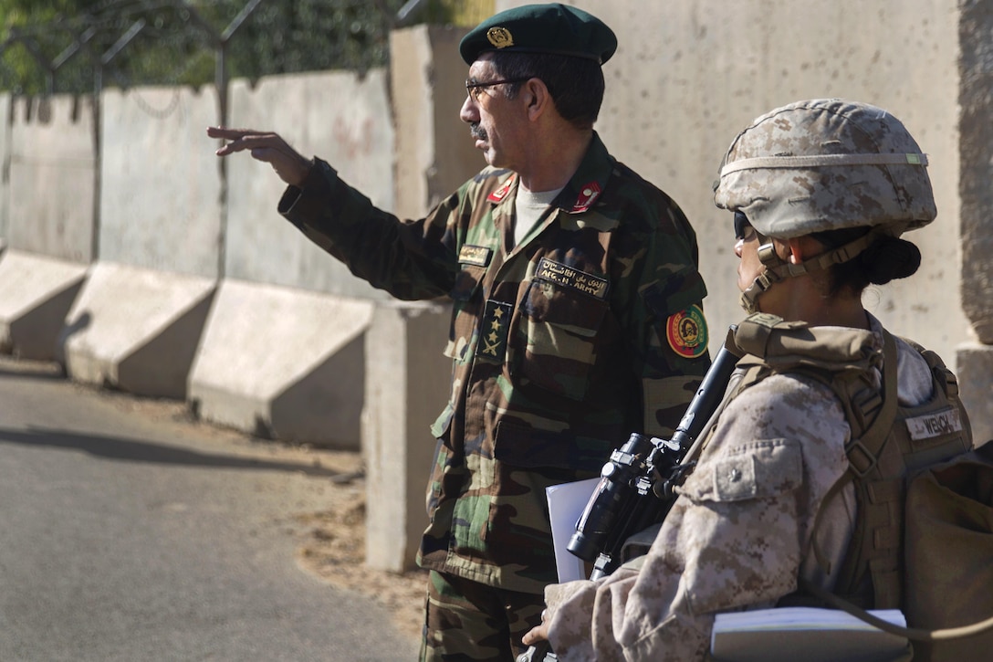 A U.S. Marine talks to an Afghan soldier.