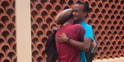 U.S. citizen David Shargel embraces his son, Naya Shargel, at Douglas-Charles Airport in Melville Hall, Dominica