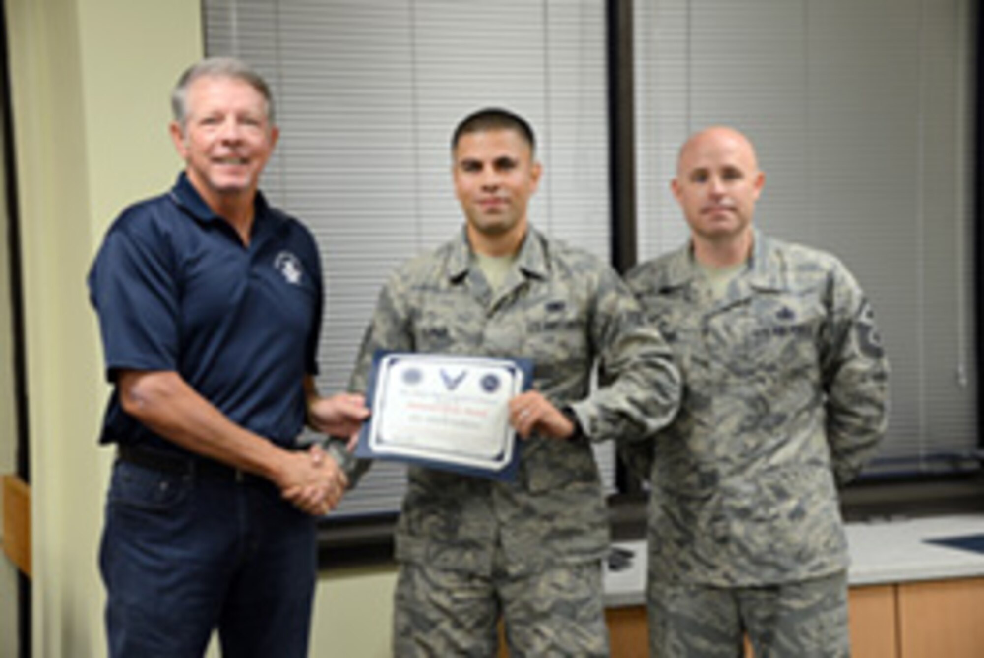 Airman 1st Class Adam Khrais, with the 552nd Maintenance Group, is presented his Diamond Sharp Award by the 15th Chief Master Sgt. of the Air Force Rodney McKinley and his first sergeant, Master Sgt. Paul Barentine.