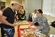 Staff Sgt. Cheila with the 960th Airborne Air Control Squadron gets ready to serve a Puerto Rican dish to Senior Airman Daniel with the 966th AACS on Sept. 21.