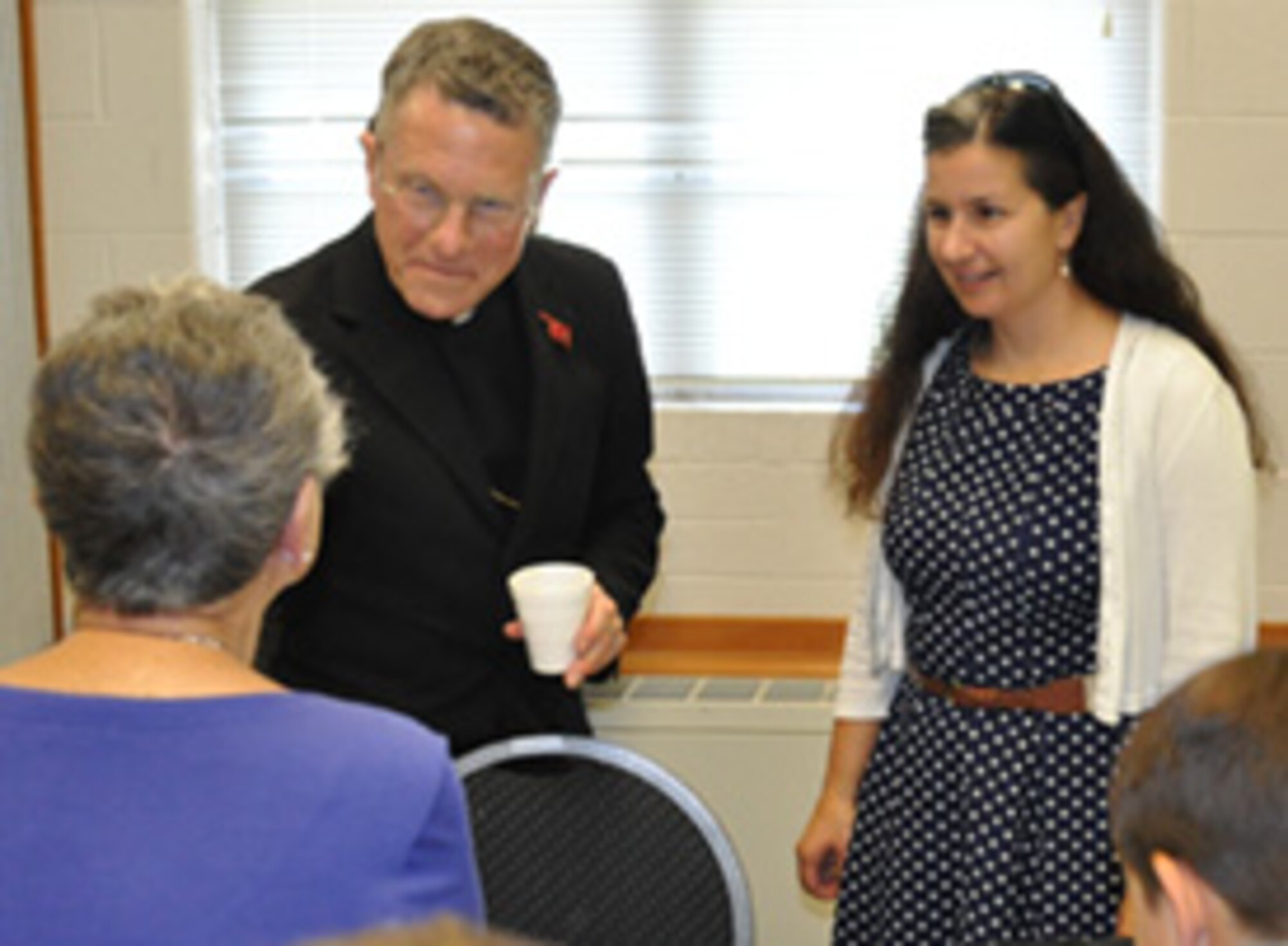 Archbishop Timothy Broglio, head of the Catholic Archdiocese for the Military Services, speaks to a Tinker Chapel parishioner Sept. 24 as Lt. Col. Heather Fleishauer, commander of the 752nd Operations Support Squadron, listens in.