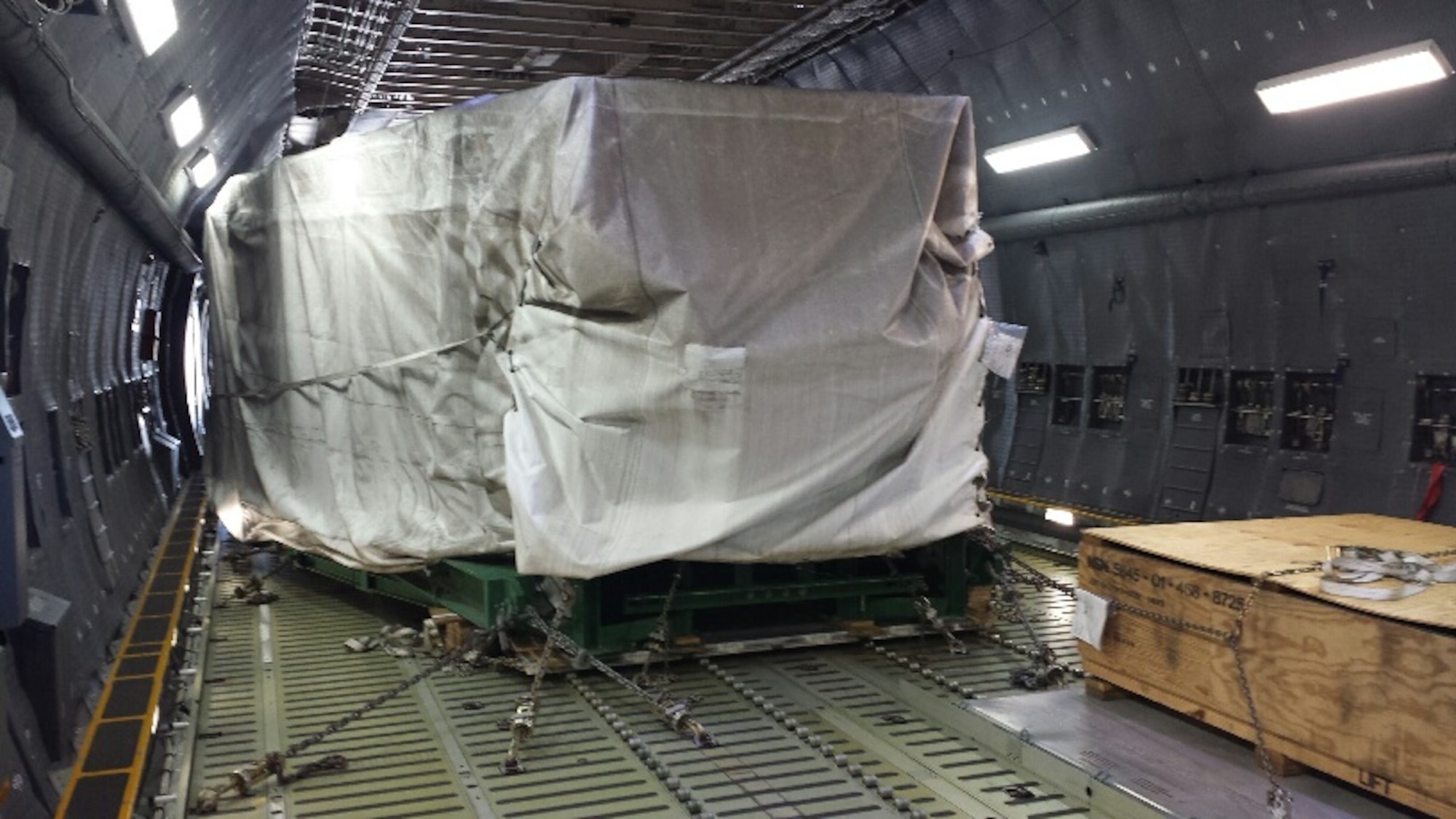 A sonar window dome being transported in a C-5 aircraft, to repair the USS Antietam, a Ticonderoga class cruiser ship which was damaged after running aground in Tokyo Bay, Japan earlier in the year. The Air Force Life Cycle Management Center's Air Transportability Test Loading Activity office located at Wright-Patterson Air Force Base, certified that the load was safe for flight and designed fixtures to restrain and protect it. (courtesy photo)