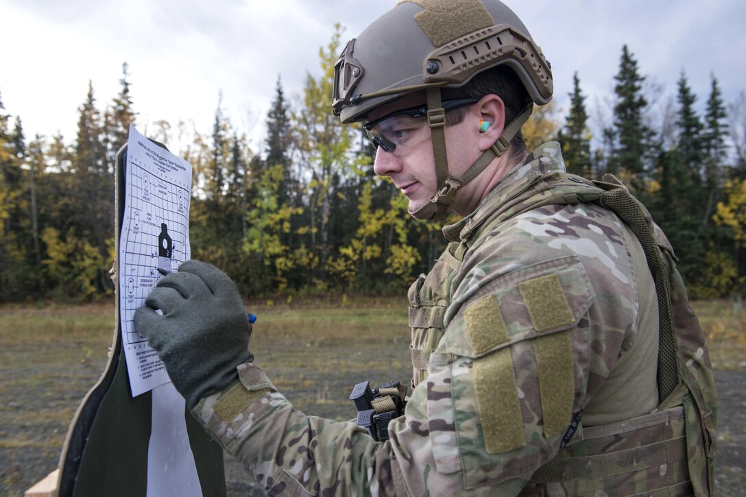 An airman writes a paper mounted on a target.
