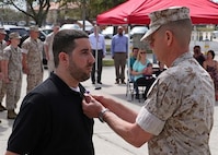 Corporal Brian P. Johnson is presented the Purple Heart medal by Lieutenant. Gen. William D. Beydler, Mar. 17, 2016, at a ceremony at MacDill Air Force Base, Fla. Johnson received the Purple Heart for injuries he sustained on 26 July 2006, during combat operations with Combined Regimental Combat Team 5, in Fallujah, Iraq. Johnson completed his active service in November of 2006. Beydler is the commander of Marine Corps Forces Central Command.