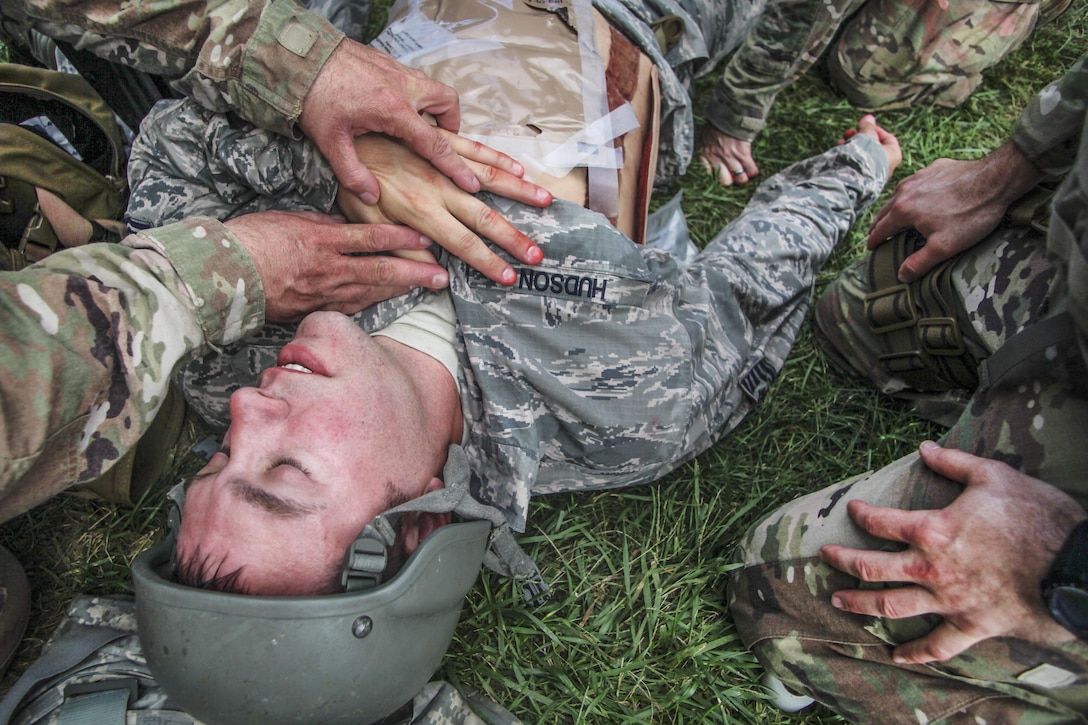 Airmen evaluate a simulated patient.