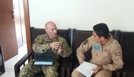 Chief Warrant Officer 4 John Silva, from the 2-149th General Support Aviation Battalion, talks with a member of the Royal Jordanian Air Force’s Squadron 8 in Amman, Jordan, Sept. 13.