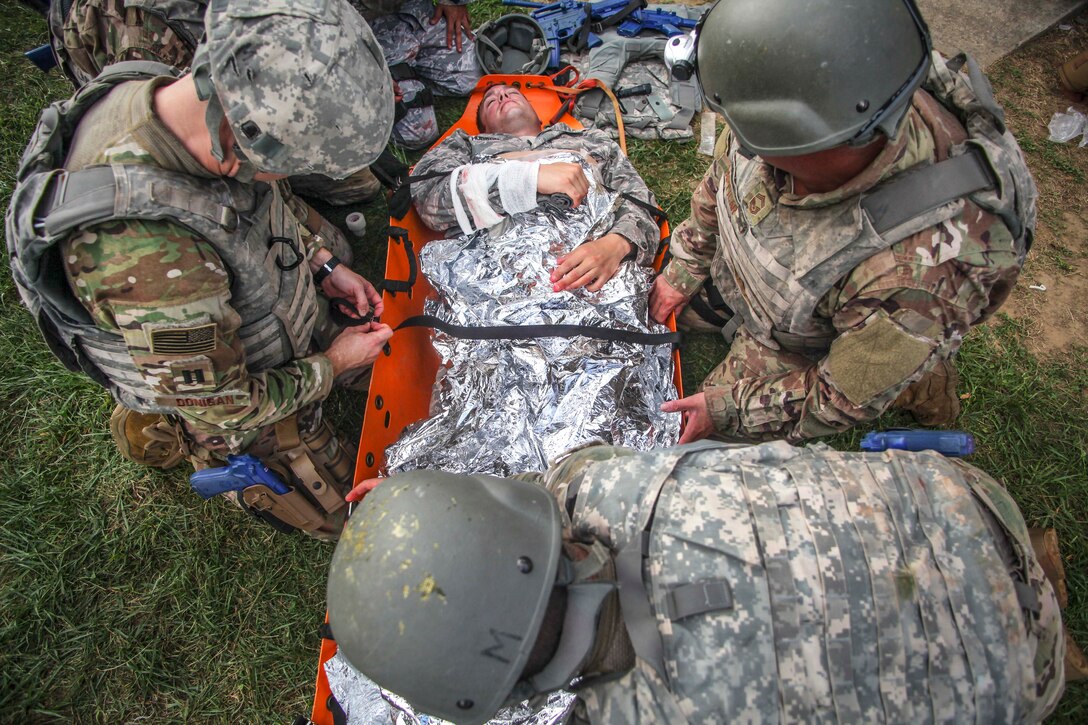 Airmen prepare to evacuate a simulated patient on a litter participating in a tactical combat casualty care class.