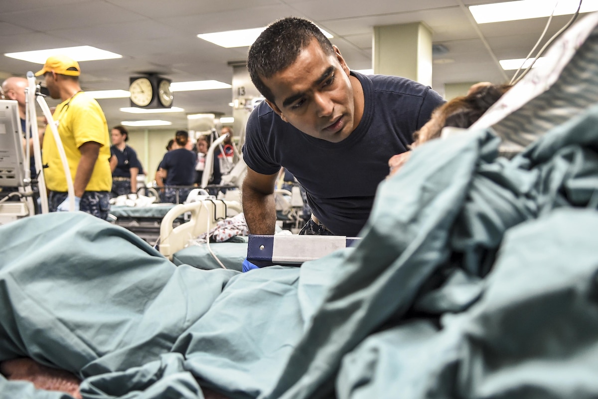 A nurse provides care to a patient on a hospital ship.