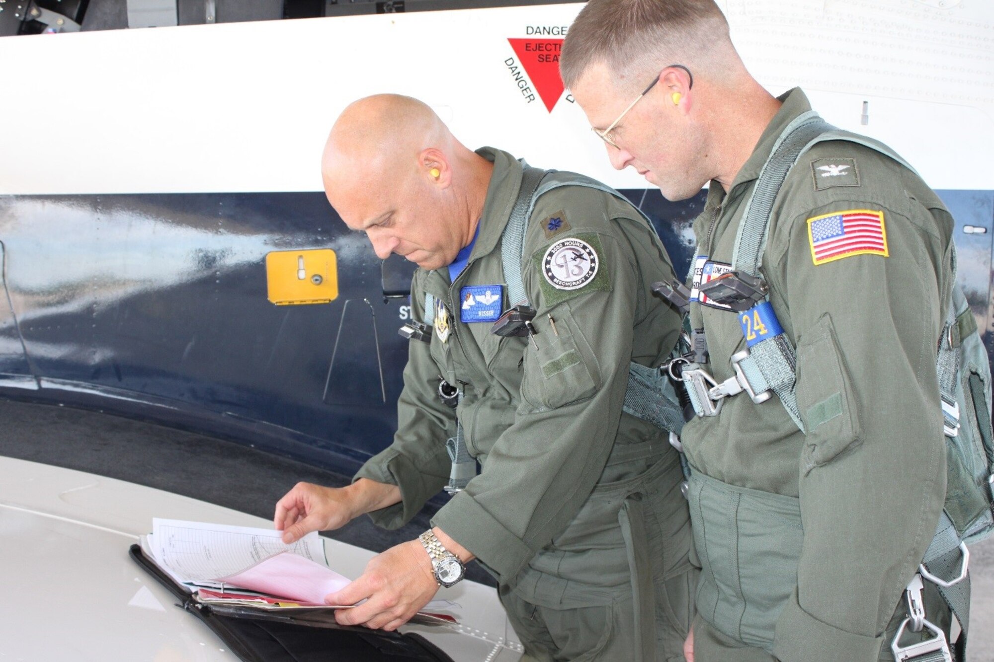 Lt. Col. Andrew Kissinger and U.S. Coast Guard Capt. Tony Hahn review their checklists before flying the T-6 Texan II. The USCG Corpus Christi sector commander/air station commanding officer reached out to the 39th Flying Training Squadron to discuss pilot retention/recruiting and reserve integration benefits. Closing out his visit, Kissinger took him on a familiarization flight. (Photo by Debbie Gildea, 340th Flying Training Group Public Affairs).