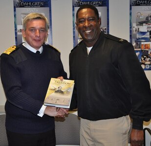 IMAGE: DAHLGREN, Va. (Oct. 2, 2017) - British Royal Navy First Sea Lord Adm. Sir Philip Jones holds the Dahlgren history book, "The Sound of Freedom," he just received from Capt. Godfrey "Gus" Weekes, Naval Surface Warfare Center Dahlgren Division (NSWCDD) commanding officer, as the two shake hands. The 1SL and his delegation toured NSWCDD laboratories and test sites for overviews on programs ranging from human systems integration and ballistic missile fire control to directed energy weapons, including the electromagnetic railgun and high energy lasers.