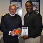 IMAGE: DAHLGREN, Va. (Oct. 2, 2017) - British Royal Navy First Sea Lord Adm. Sir Philip Jones presents a book on the Royal Navy and a plaque to Capt. Godfrey "Gus" Weekes, Naval Surface Warfare Center Dahlgren Division (NSWCDD) commanding officer, during his tour of NSWCDD. The 1SL and his delegation toured NSWCDD laboratories and test sites for overviews on programs ranging from human systems integration and ballistic missile fire control to directed energy weapons, including the electromagnetic railgun and high energy lasers. The command provides research, development, test and evaluation, analysis, systems engineering, integration and certification of complex naval warfare systems.