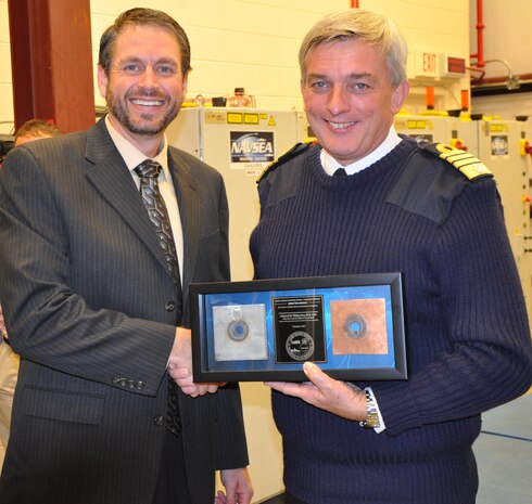 IMAGE: DAHLGREN, Va. (Oct. 2, 2017) - British Royal Navy First Sea Lord Adm. Sir Philip Jones holds a shadow box he received from Dr. Chris Lloyd, High Energy Laser Lethality lead at Naval Surface Warfare Center Dahlgren Division (NSWCDD), as the two shake hands. This presentation of the shadow box - which contains steel and copper metal samples irradiated and penetrated in NSWCDD's High Energy Laser Lethality laboratory - occurred moments before the 1SL witnessed a live test demonstration.