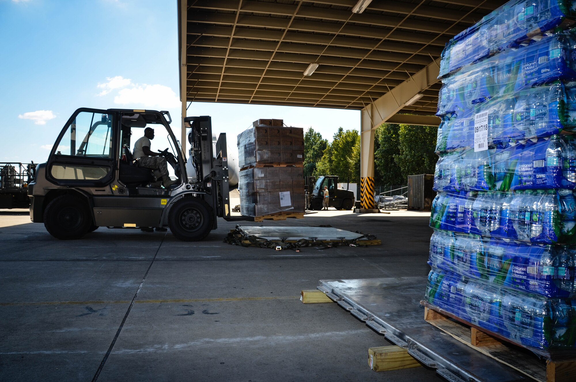 Staff Sgt. Kens Germain, an aerial porter from Joint Base McGuire-Dix-Lakehurst, New Jersey, positions a forklift to set down a stack of ready-to-eat meals at Dobbins Air Reserve Base, Ga., Oct. 4. A total of 23,390 pounds of food and water will be transported to Puerto Rico and distributed to those in need. (U.S. Air Force photo by Tech. Sgt. Kelly Goonan)