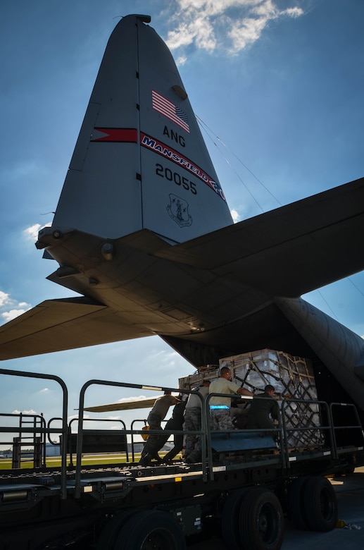 Airmen position a K-loader carrying water and ready-to-eat meals behind a C-130 Hercules at Dobbins Air Reserve Base, Ga. Oct. 4. Airmen loaded a Mansfield Air National Guard C-130 with a total of 23,390 pounds of food and water which will be transported to Puerto Rico and distributed to those in need. (U.S. Air Force photo by Tech. Sgt. Kelly Goonan)