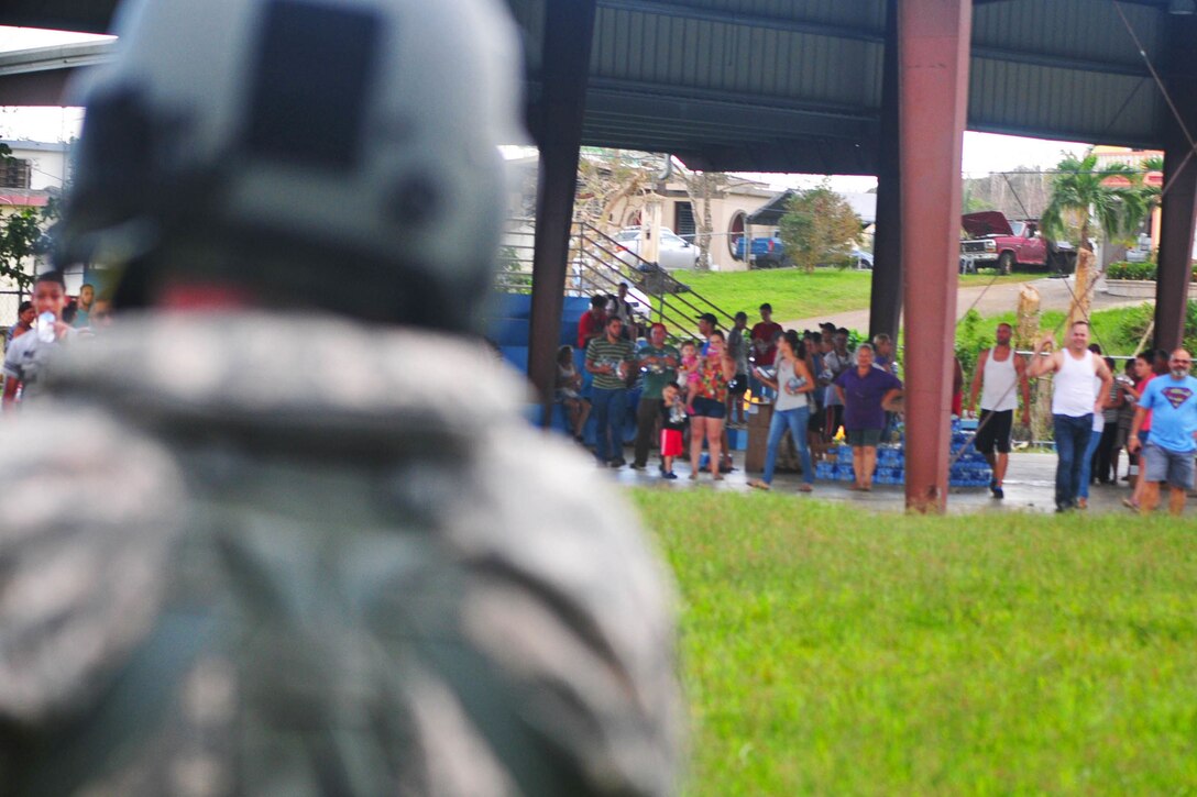 A guardsman look toward a group of people.