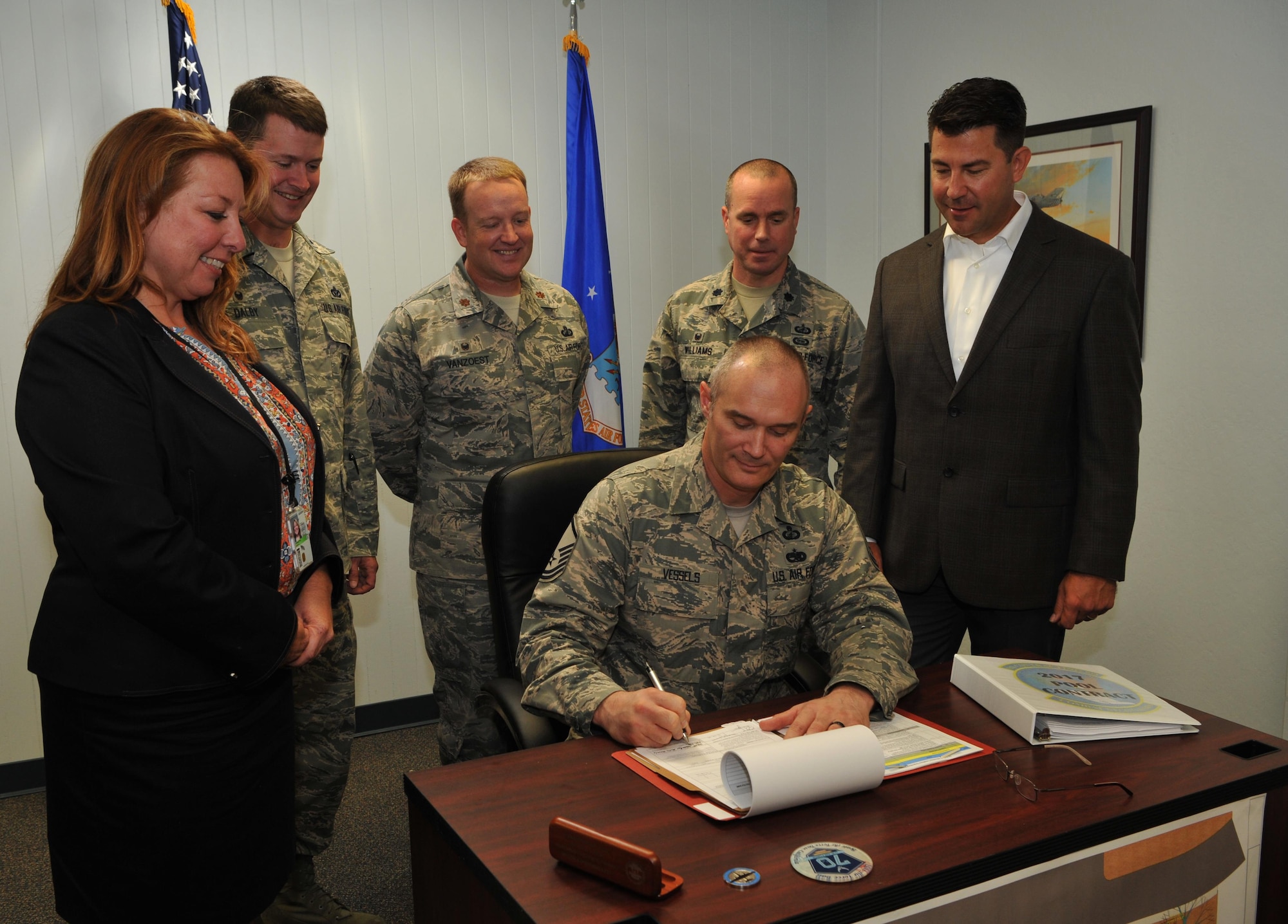 Master Sgt. Martin Vessels, 9th Contracting Squadron construction flight chief, signs a contract regarding upcoming renovations to the pool in base housing